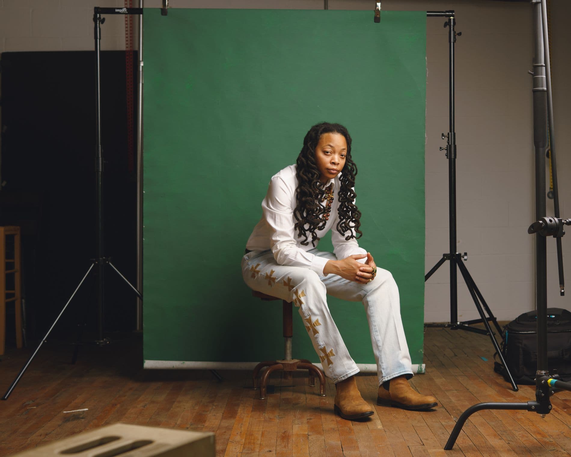 Crys Adams in her Atlanta studio before a green backdrop.